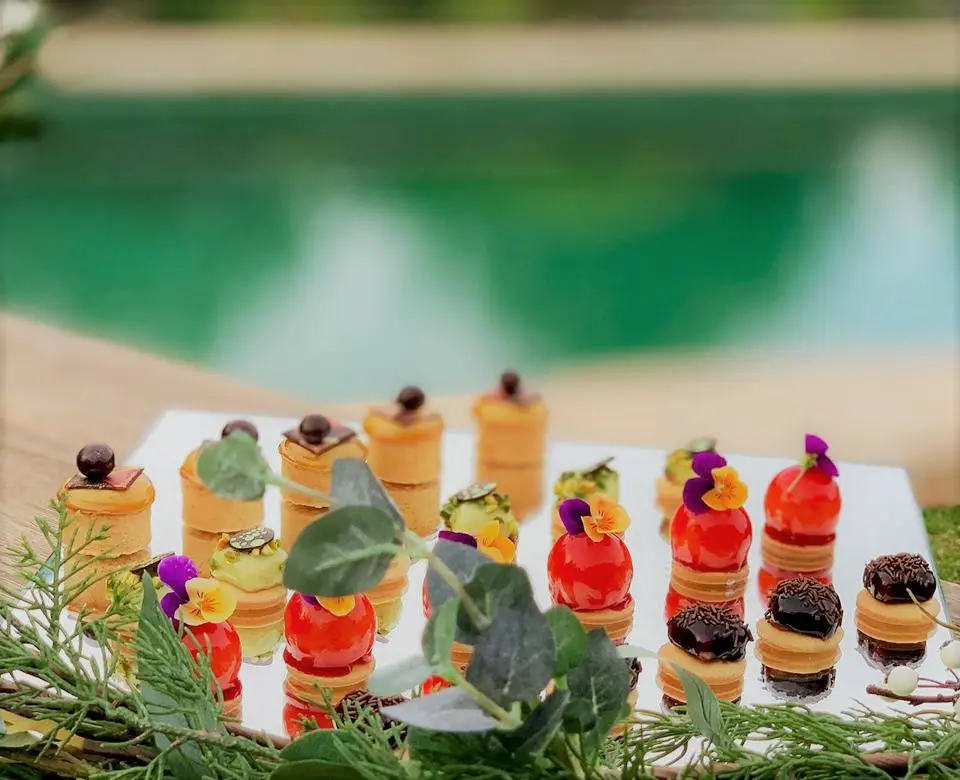 Small cakes on a table, near a swimming pool